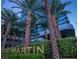 Luxury high-rise building featuring lush landscaping and palm trees at the entrance with elegant gold signage at 4471 Dean Martin Dr # 1207, Las Vegas, NV 89103