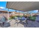 Back patio area featuring a covered patio with outdoor seating and decor, and a grassy yard at 4655 Fire Fly Cir, Las Vegas, NV 89122