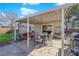 Covered back patio with outdoor seating, a grill, and an American flag in a rock and grassy yard at 4655 Fire Fly Cir, Las Vegas, NV 89122