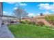 Manicured backyard featuring a lush green lawn, mature landscaping, and a cozy swing at 4655 Fire Fly Cir, Las Vegas, NV 89122
