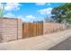 Wooden backyard gate between masonry block walls creates a private space with mature shade tree and drought tolerant landscaping at 4655 Fire Fly Cir, Las Vegas, NV 89122