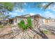 Single-story home with a stone accent wall, desert landscaping, and an attached two-car garage at 4655 Fire Fly Cir, Las Vegas, NV 89122