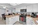 Well-lit kitchen with stainless appliances, gas range, white cabinetry, and a breakfast bar at 4655 Fire Fly Cir, Las Vegas, NV 89122