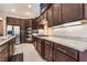 Modern kitchen featuring granite countertops, stainless steel appliances, and dark wood cabinetry at 5027 Crown Cypress St, Las Vegas, NV 89149