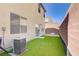 Artificial grass, patio, air conditioner and the property's boundary provide a low-maintenance landscape at 5948 Sakhalin Ave, Las Vegas, NV 89139