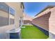 Artificial grass, patio, air conditioner and the property's boundary provide a low-maintenance landscape at 5948 Sakhalin Ave, Las Vegas, NV 89139