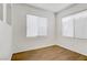 Bright bedroom with wood-look floors and ample natural light from two large windows at 5948 Sakhalin Ave, Las Vegas, NV 89139