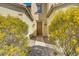 A charming front entryway with a wooden door, framed by vibrant, mature landscaping at 5948 Sakhalin Ave, Las Vegas, NV 89139