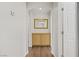 Bright hallway featuring wood flooring, white walls, and decorative cabinet with mirror at 5948 Sakhalin Ave, Las Vegas, NV 89139