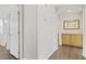 Hallway with wood flooring leading to rooms with light wood cabinets and mirror at 5948 Sakhalin Ave, Las Vegas, NV 89139