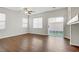 Open floorplan living room with hardwood flooring, ceiling fan, and a glass sliding door at 5948 Sakhalin Ave, Las Vegas, NV 89139