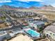 Stunning aerial view of a community pool and surrounding homes, set against a backdrop of majestic mountains at 600 N Carriage Hill Dr # 1164, Las Vegas, NV 89138