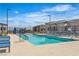 Resort-style community pool with lounge chairs, umbrellas, and clear blue water for leisure and relaxation at 600 N Carriage Hill Dr # 1164, Las Vegas, NV 89138