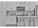 Modern kitchen featuring white cabinetry, stainless steel appliances, and a stylish breakfast bar with seating at 600 N Carriage Hill Dr # 1164, Las Vegas, NV 89138
