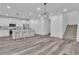 Open-concept kitchen and living area with island seating, white cabinets, and wood staircase at 600 N Carriage Hill Dr # 1164, Las Vegas, NV 89138