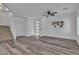 Bright living room features a modern ceiling fan, wood staircase, and gray laminate flooring at 600 N Carriage Hill Dr # 1164, Las Vegas, NV 89138