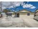 Single-story home featuring a large driveway, desert landscaping and blue trim at 6710 Redwood Cir, Las Vegas, NV 89103