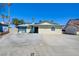 Charming single-story home featuring a large driveway, desert landscaping and clear blue skies at 6710 Redwood Cir, Las Vegas, NV 89103