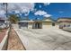 Single-story home featuring a large driveway, desert landscaping and blue trim at 6710 Redwood Cir, Las Vegas, NV 89103