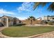 Spacious backyard featuring artificial grass, a storage shed, mature palms and RV parking at 78 Siddall Ave, Las Vegas, NV 89183