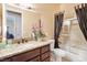 Cozy bathroom with granite counters, dark wood cabinets, shower and separate soaking tub at 78 Siddall Ave, Las Vegas, NV 89183