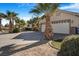 Spacious home featuring a three-car garage, desert landscaping, and mature palm trees at 78 Siddall Ave, Las Vegas, NV 89183
