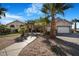 Attractive home featuring desert landscaping, mature palm trees and a three-car garage at 78 Siddall Ave, Las Vegas, NV 89183