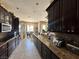 Stylish kitchen featuring dark wood cabinets, granite countertops, stainless steel appliances and tile floors at 78 Siddall Ave, Las Vegas, NV 89183