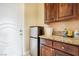 A laundry room features a mini fridge, granite countertops, and wooden cabinets at 78 Siddall Ave, Las Vegas, NV 89183