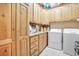 Large laundry room with wooden cabinets, granite countertop and modern washer/dryer at 78 Siddall Ave, Las Vegas, NV 89183