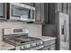 Detailed shot of stainless steel microwave and oven appliance with granite countertops and white backsplash at 783 Hibiscuss Blossom St, Henderson, NV 89011