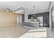 Open-concept kitchen and living area boasts modern lighting, stainless appliances, and island with breakfast bar at 783 Hibiscuss Blossom St, Henderson, NV 89011