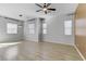 Bright living room featuring modern ceiling fan, multiple windows, and wood-look flooring throughout at 783 Hibiscuss Blossom St, Henderson, NV 89011