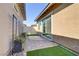 Paver patio featuring artificial grass and black planters with flowering vines for outdoor living and decor at 783 Hibiscuss Blossom St, Henderson, NV 89011