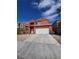 Charming two-story home with orange stucco exterior and a two car garage on a sunny day at 8124 Kokoma Dr, Las Vegas, NV 89128