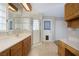 Bright bathroom featuring a glass enclosed shower and double sink vanity with wood cabinets at 904 Hibiscus Ct, Henderson, NV 89011