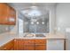 Galley style kitchen with stainless steel sink, wood cabinets, and white appliances at 9117 Careful Canvas Ave, Las Vegas, NV 89149