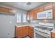 Well-lit kitchen equipped with wood cabinetry, white appliances, and stylish window accents at 9117 Careful Canvas Ave, Las Vegas, NV 89149