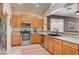 Well-lit kitchen features wood cabinets, stainless steel appliances, and a view into the living space at 97 Zimmerman St, Henderson, NV 89002