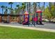Community playground with colorful play structure, picnic tables, and mature palm trees at 97 Zimmerman St, Henderson, NV 89002