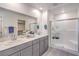 Bathroom with dual sink vanity, quartz countertops, and glass enclosed shower at 1027 Gentle Swan St # 689, Henderson, NV 89011