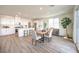 Open-concept kitchen and dining area featuring white cabinets, stainless steel appliances, and light wood-look floors at 1027 Gentle Swan St # 689, Henderson, NV 89011