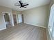 Spacious bedroom features light wood floors, a ceiling fan, and access to the bathroom and walk-in closet at 1131 Lupin St, Pahrump, NV 89048