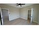 Bedroom with ceiling fan, wood floors, and doors leading to closets at 1131 Lupin St, Pahrump, NV 89048