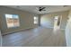 Spacious bedroom features wood-look flooring, fan, and large windows allowing natural light at 1131 Lupin St, Pahrump, NV 89048