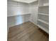 Walk-in closet with built-in shelving and wood-look floors offering plenty of storage space at 1131 Lupin St, Pahrump, NV 89048