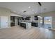 Open kitchen floor plan featuring an island, modern appliances, dark cabinets and light wood flooring at 1131 Lupin St, Pahrump, NV 89048