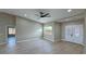 Bright living room with ceiling fan, and wood-look floors with double doors at 1131 Lupin St, Pahrump, NV 89048