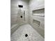 Shower showcasing stylish tile design, built-in shower caddy, and modern rain shower fixture at 1131 Lupin St, Pahrump, NV 89048
