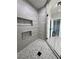 Modern walk-in shower features sleek gray tiling and built-in shelving, adjoining the Primary bathroom at 1131 Lupin St, Pahrump, NV 89048